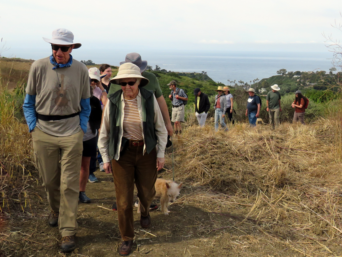 Couple leading trail walk overlooking ocean in Elings Park Santa Barbara, California