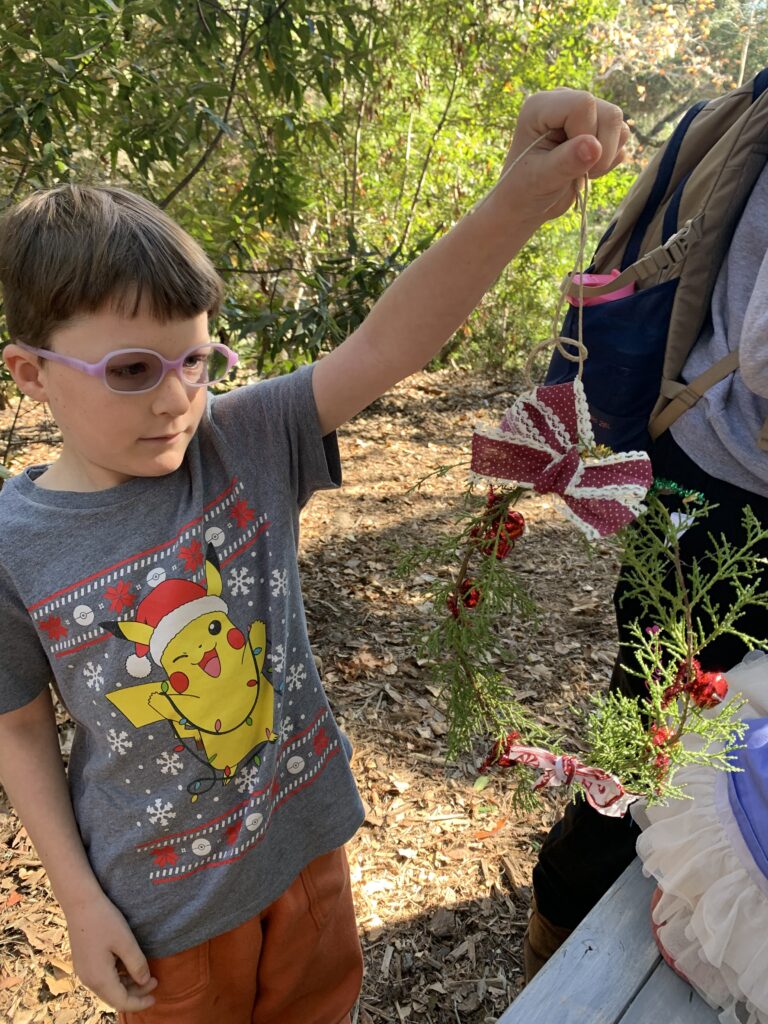 child holding holiday craft made at the Garden