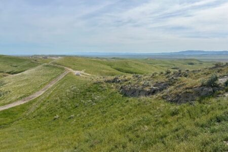 White truck seen on remote roads within a vast California spring landscape under blue sky