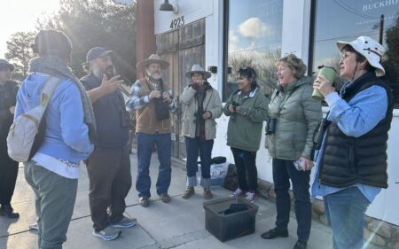 A group of birders gathering in a circle to discuses the days events
