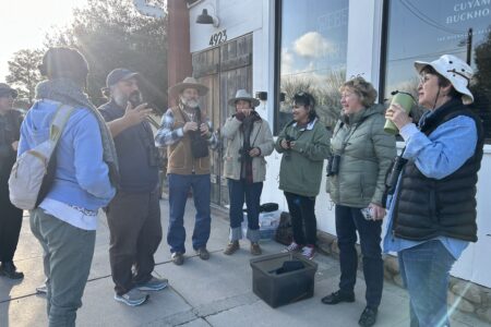 A group of birders gathering in a circle to discuses the days events