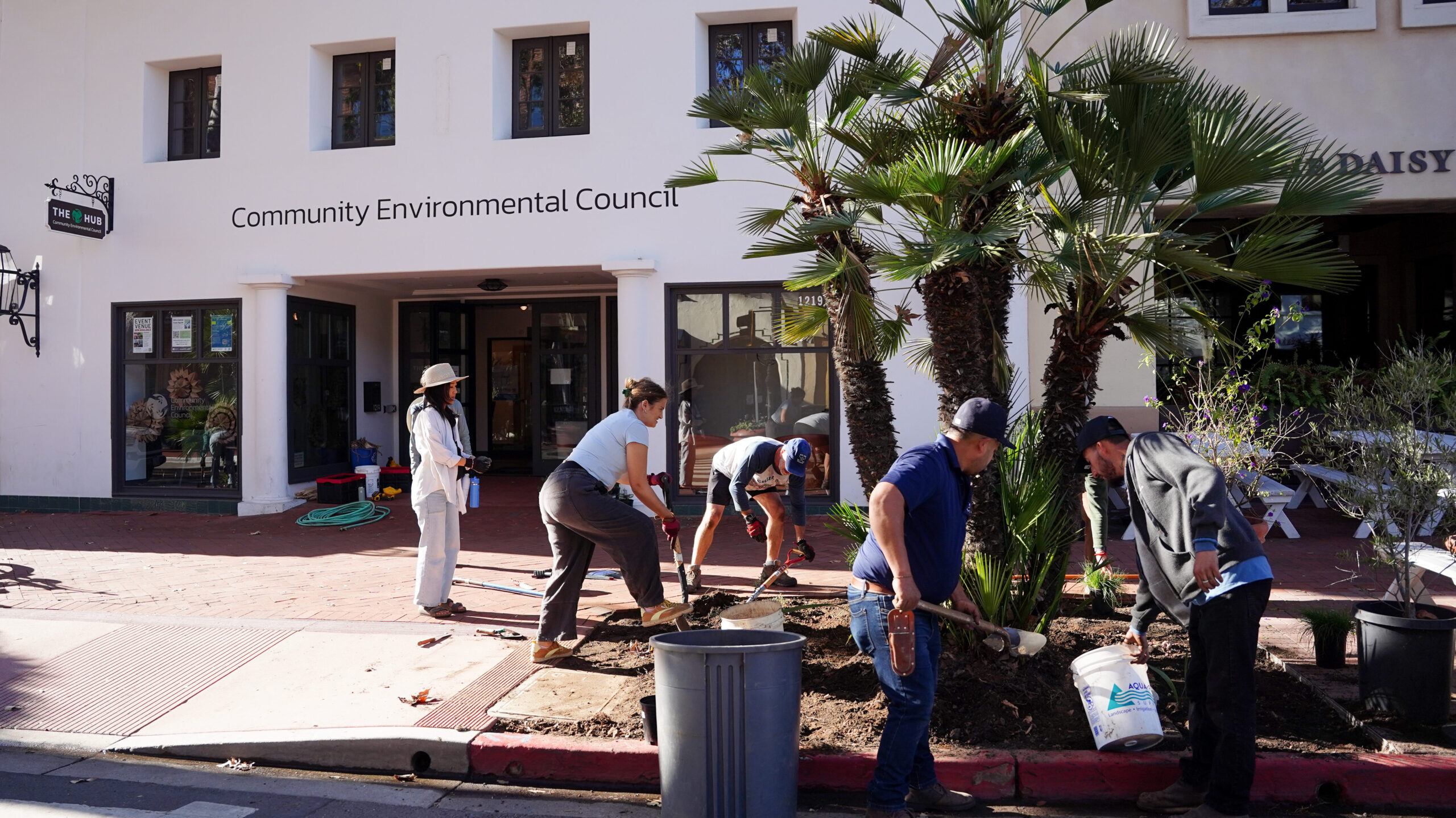 Crew on State St. adding native plants to gardening beds in front of Community Environmental Council