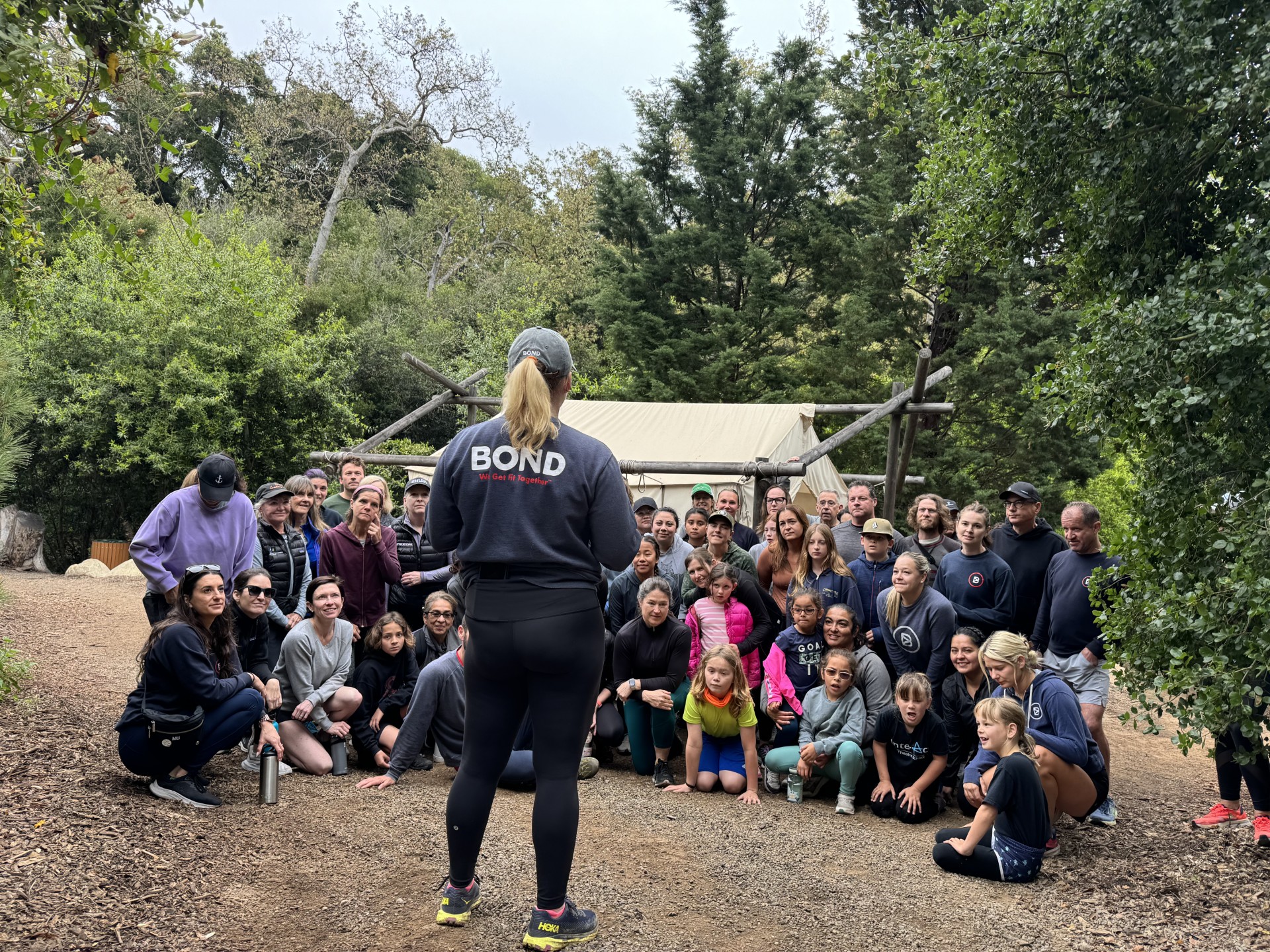 Leader standing in front of group with shirt that reads BOND Fitness